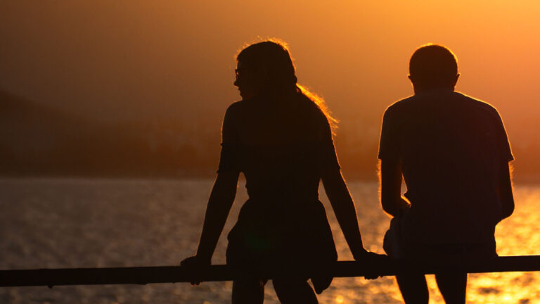 Couple sitting apart and reflecting on an unhappy relationship